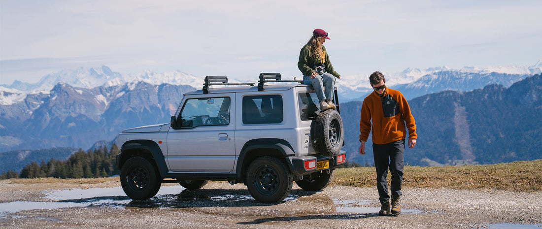 Two people and their jeep on a mountain pass