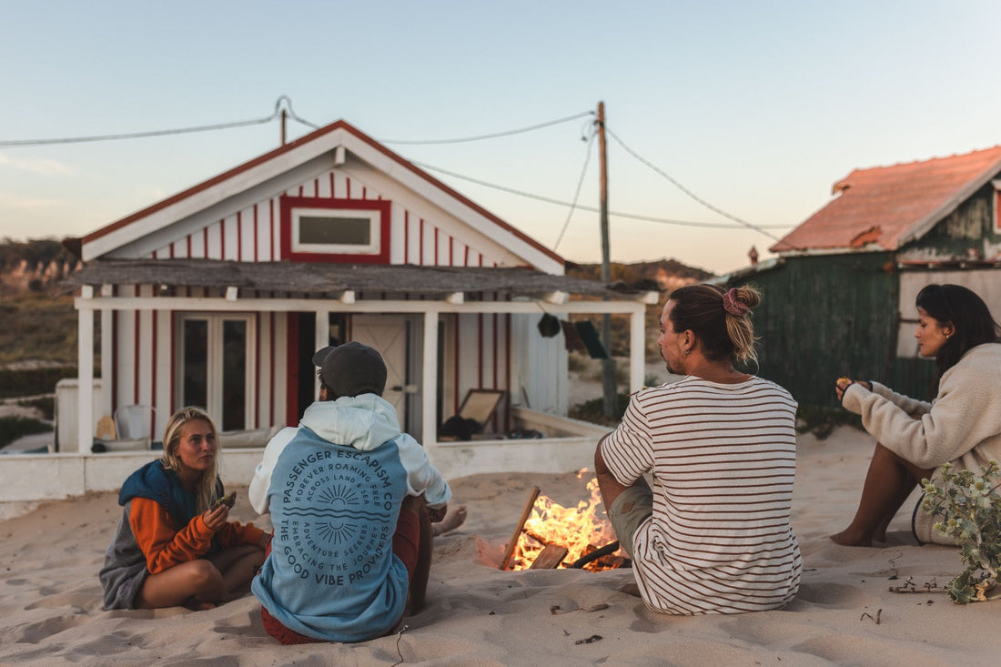 Four friends sit around a campfire talking